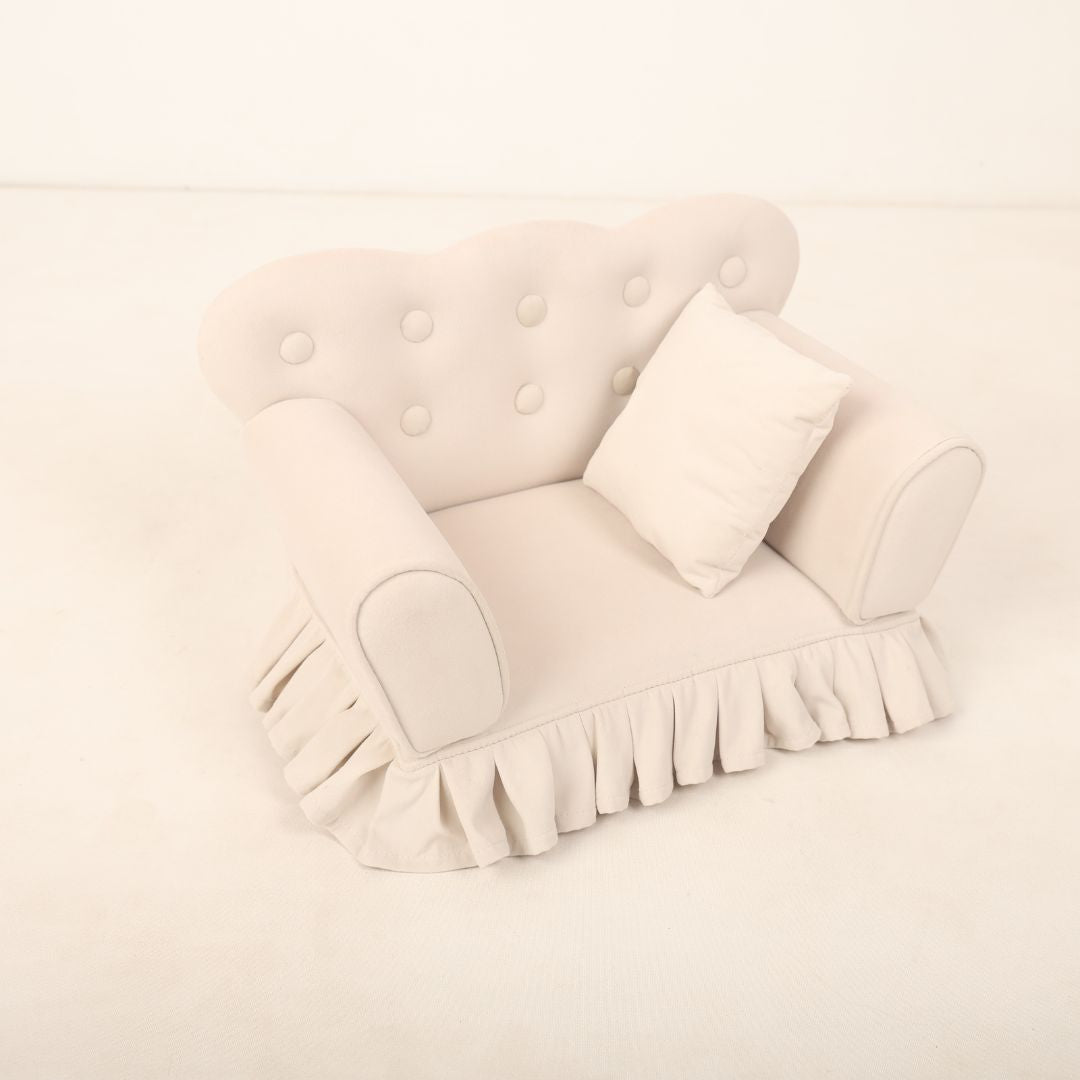 A small, cozy sofa prop designed for baby photoshoots, featuring soft cushions and neutral tones. The sofa is perfectly sized for newborns or infants or toddlers, creating a charming setting ideal for capturing adorable photos