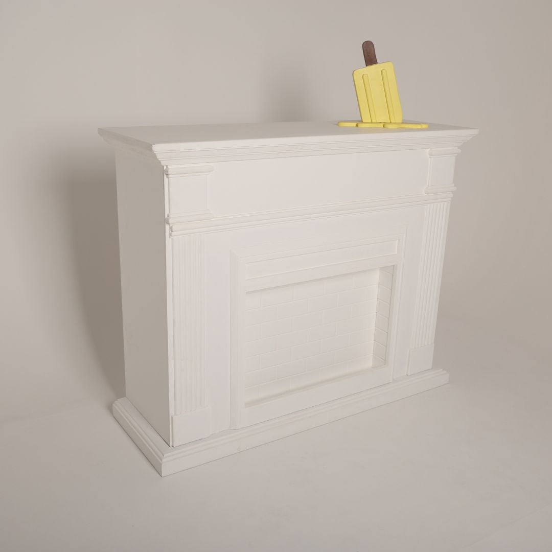 Elegant white fireplace prop styled for a cozy maternity photoshoot setup