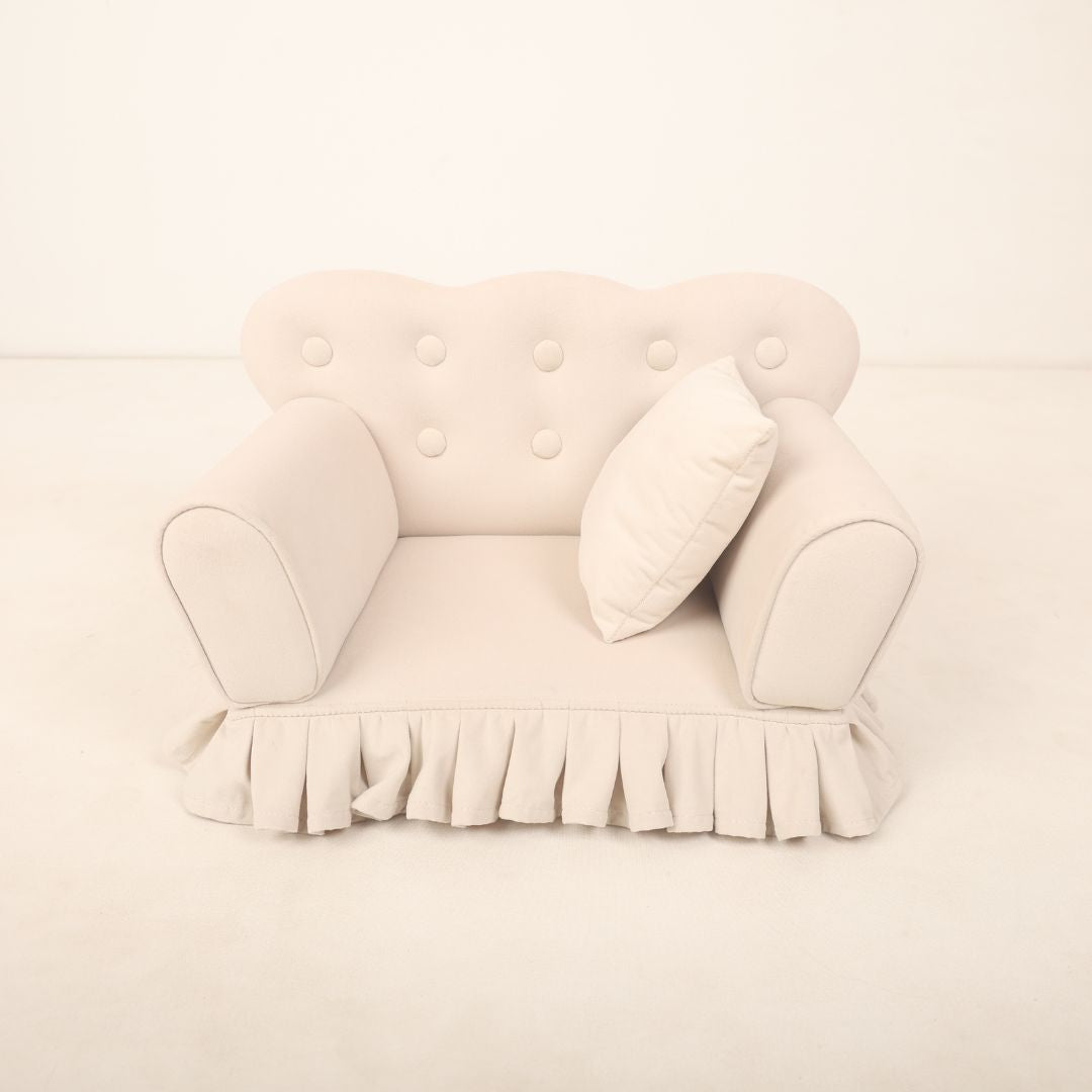  A small, cozy sofa prop designed for baby photoshoots, featuring soft cushions and neutral tones. The sofa is perfectly sized for newborns or infants or toddlers, creating a charming setting ideal for capturing adorable photos