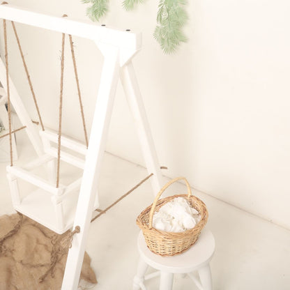 Wooden swing baby prop with soft cushions and decorative ropes, designed for newborn and toddler photoshoots, adding a playful and whimsical charm to any setup.