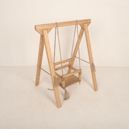 Wooden swing baby prop with soft cushions and decorative ropes, designed for newborn and toddler photoshoots, adding a playful and whimsical charm to any setup.
