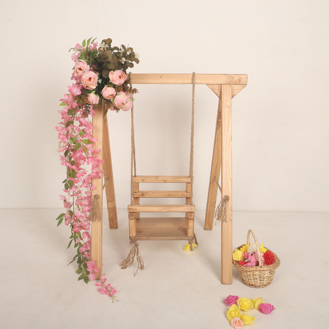 Wooden swing baby prop with soft cushions and decorative ropes, designed for newborn and toddler photoshoots, adding a playful and whimsical charm to any setup.