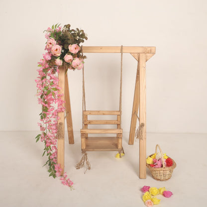 Wooden swing baby prop with soft cushions and decorative ropes, designed for newborn and toddler photoshoots, adding a playful and whimsical charm to any setup.