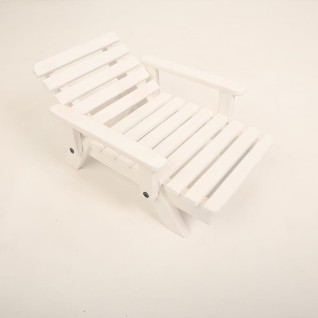 A mini wooden beach bench surrounded by sand and seashells, styled as a coastal-themed baby photoshoot prop for creating a beach-inspired setting.