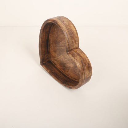 A wooden heart-shaped bowl designed as a prop for newborn baby photoshoots. The bowl has smooth edges and a natural wood finish, providing a cozy and charming setting to cradle a baby. Ideal for capturing heartfelt and memorable moments.
