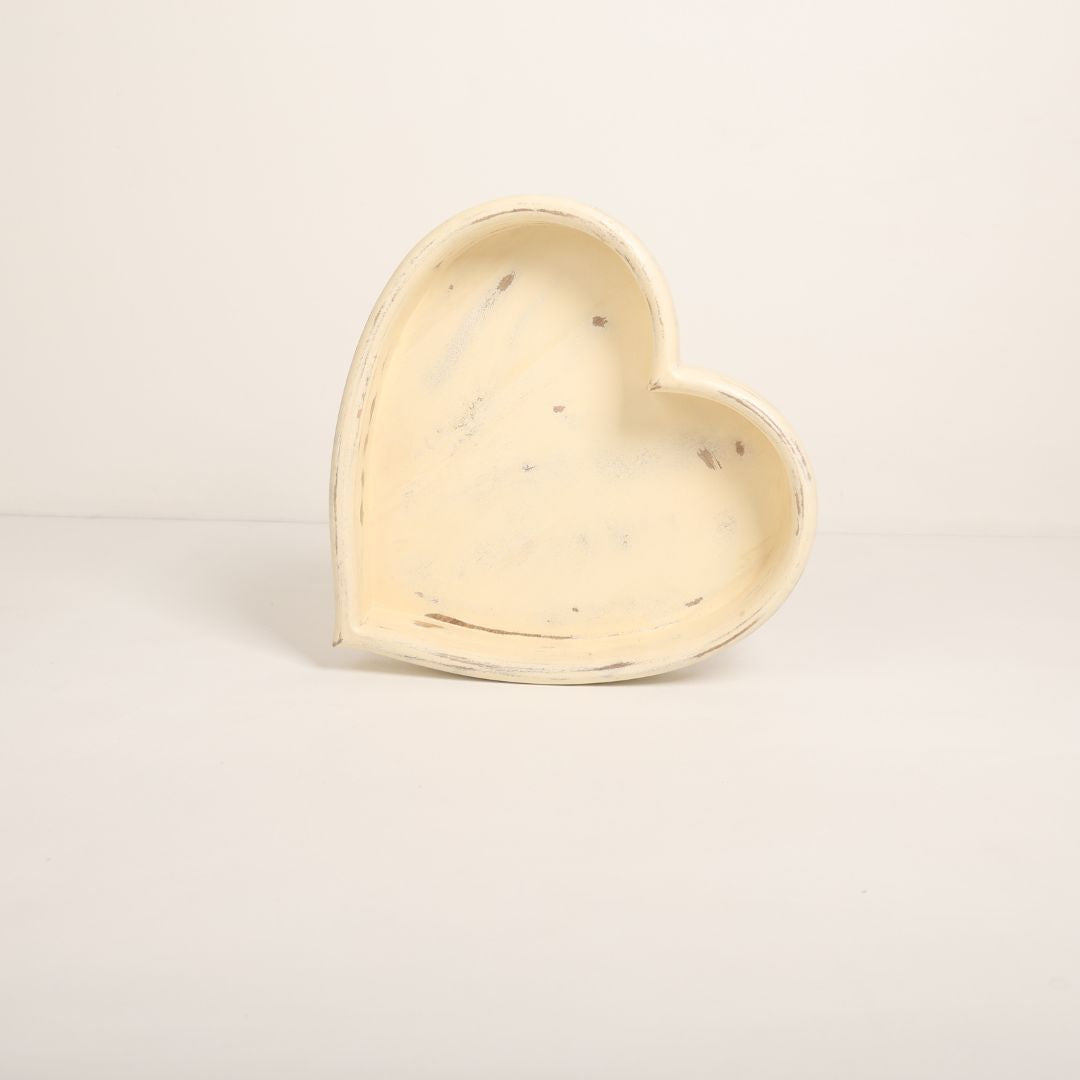 A wooden heart-shaped bowl designed as a prop for newborn baby photoshoots. The bowl has smooth edges and a natural wood finish, providing a cozy and charming setting to cradle a baby. Ideal for capturing heartfelt and memorable moments.