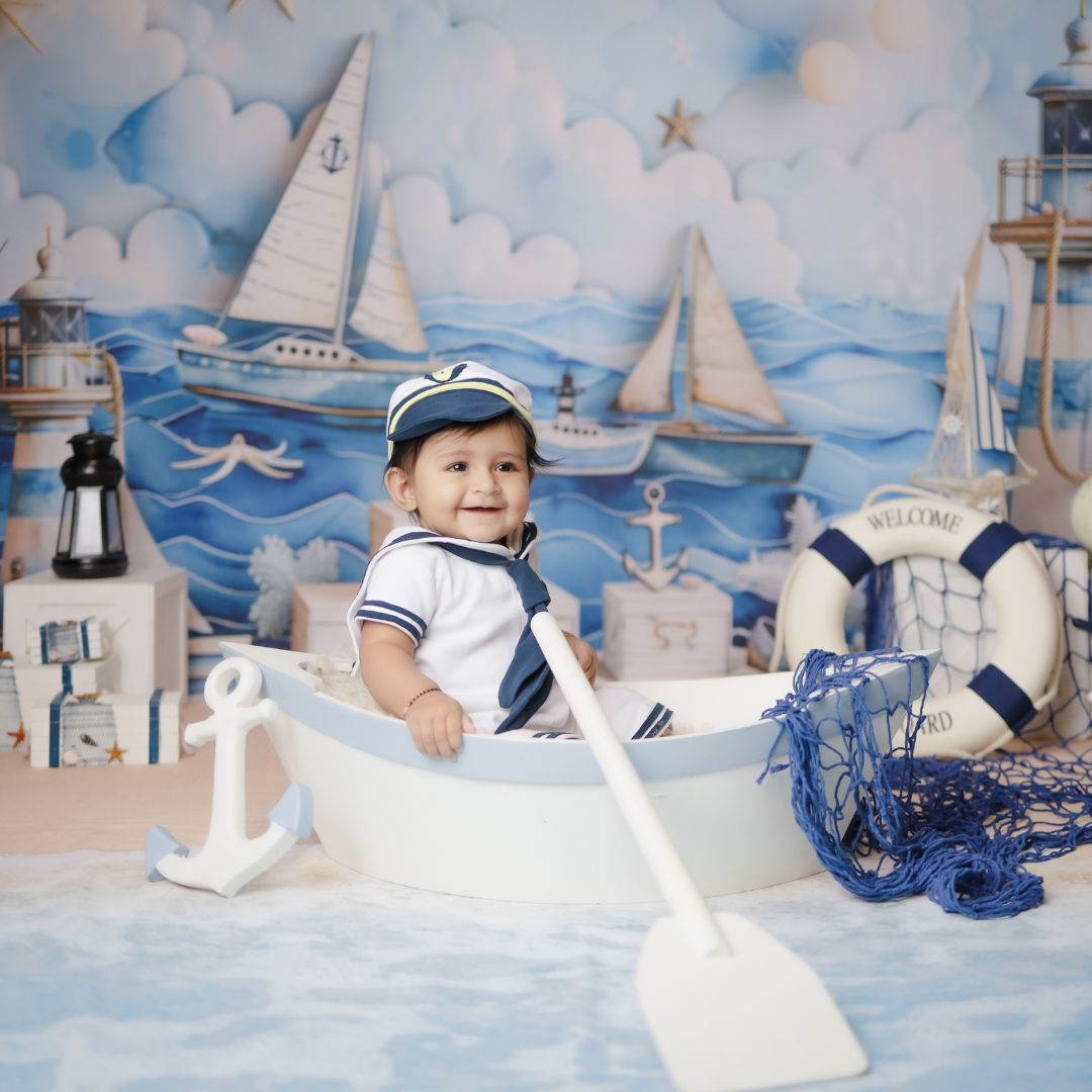 Baby sitting on a boat during a sailor themed baby photoshoot