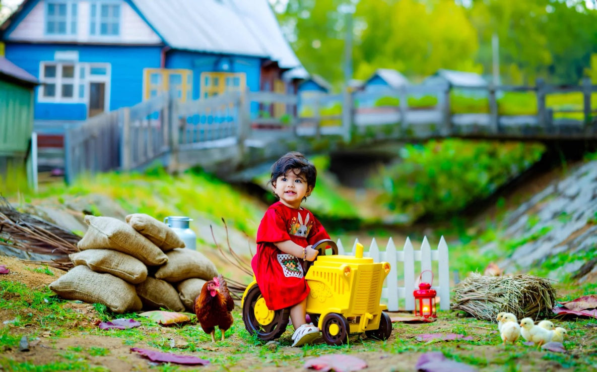 Baby sitting on a tractor baby prop for a themed baby photoshoot.