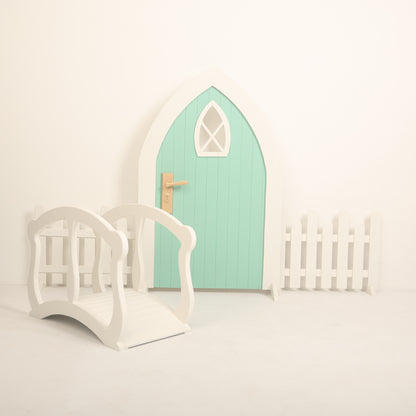 Baby photoshoot setup featuring an arch door, wooden fences, and a mini bridge – perfect for newborn and toddler photography themes.
