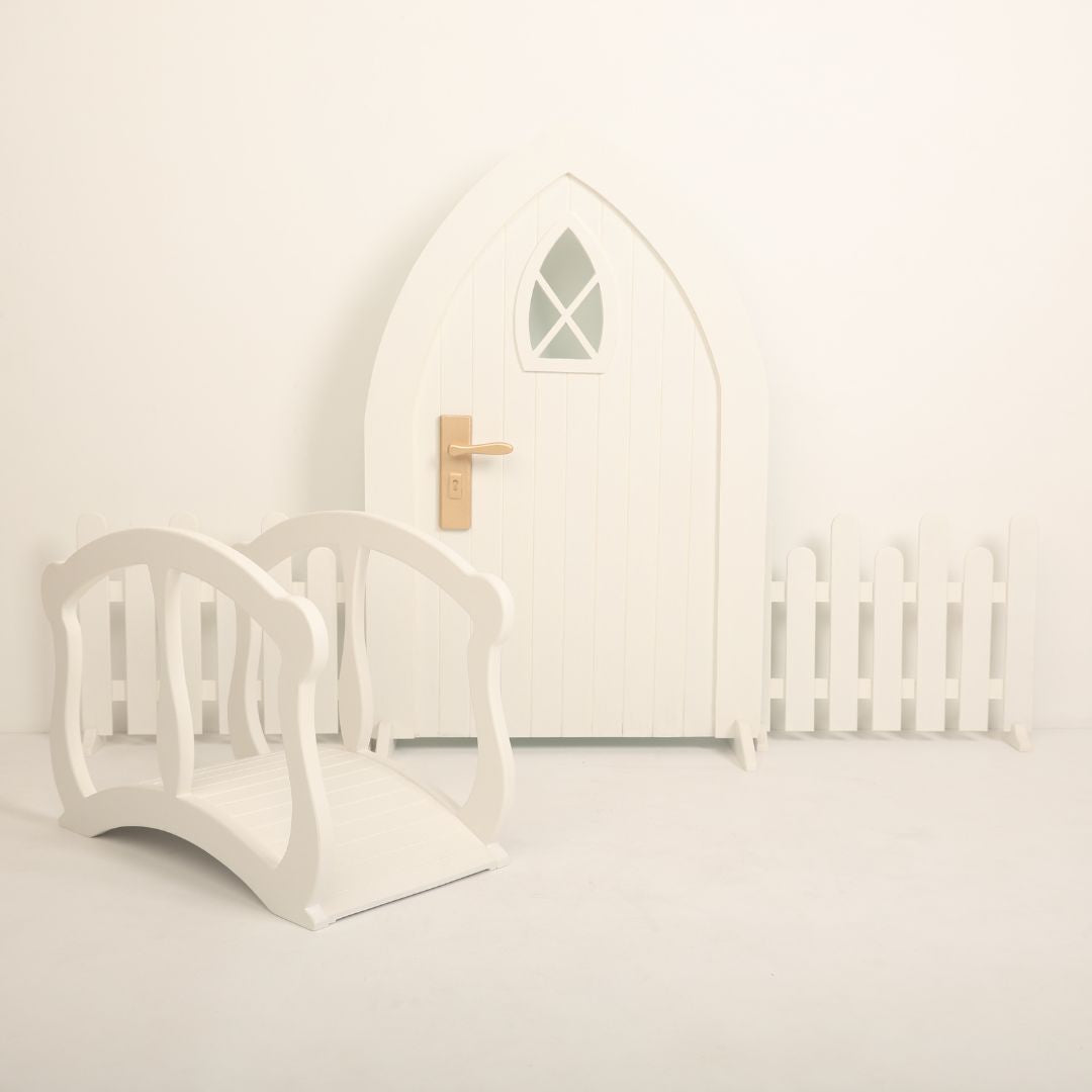 Baby photoshoot setup featuring an arch door, wooden fences, and a mini bridge – perfect for newborn and toddler photography themes.