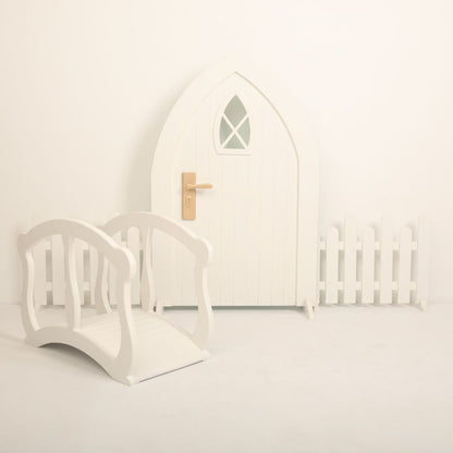 Baby photoshoot setup featuring an arch door, wooden fences, and a mini bridge – perfect for newborn and toddler photography themes.