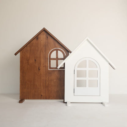 A wooden house-shaped baby prop styled for newborn photography, featuring rustic details perfect for a cottage-themed photoshoot.