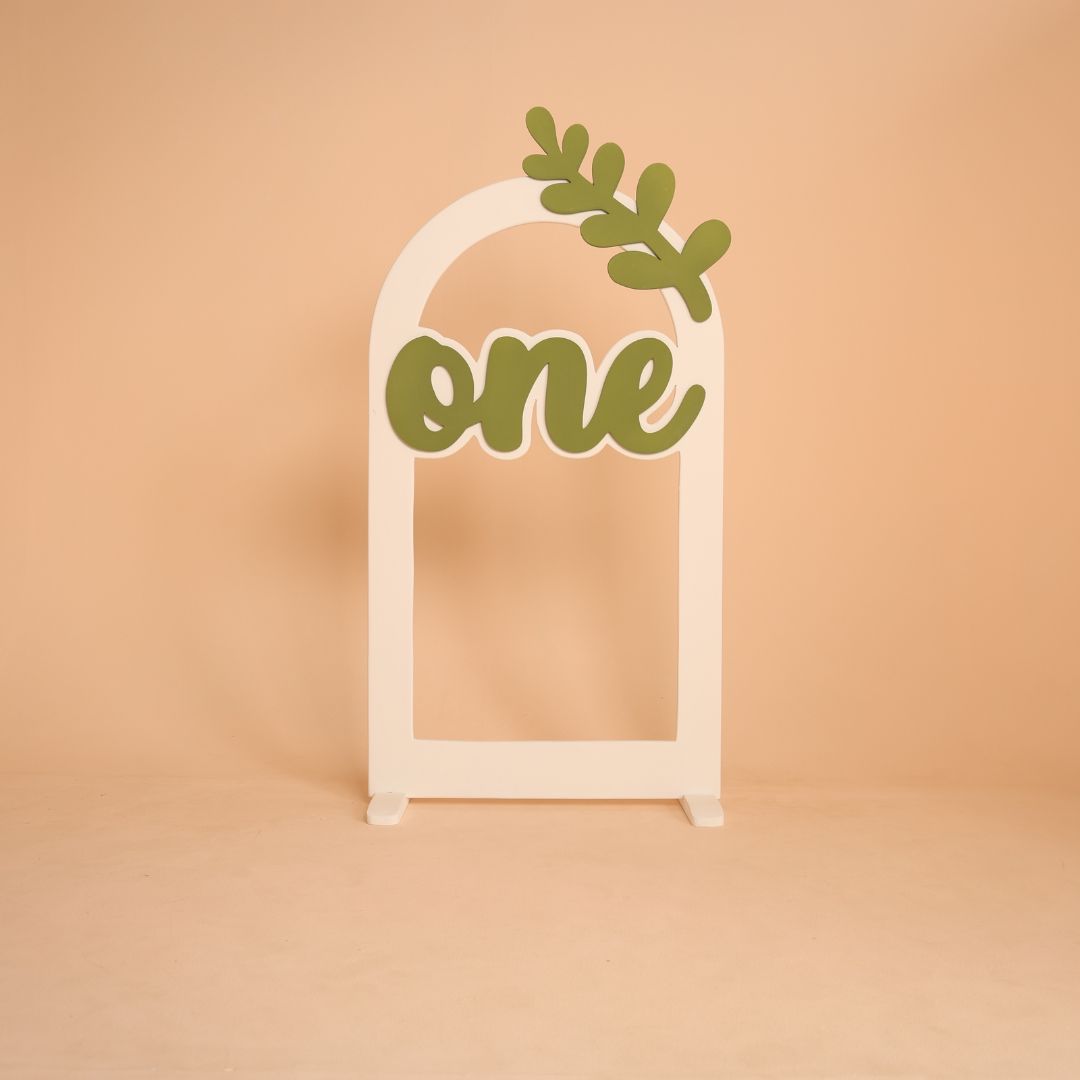 Leaf themed arch baby photoshoot prop with one milestone, nature inspired setup for first birthday shoot