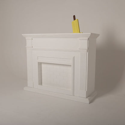 Elegant white fireplace prop styled for a cozy maternity photoshoot setup