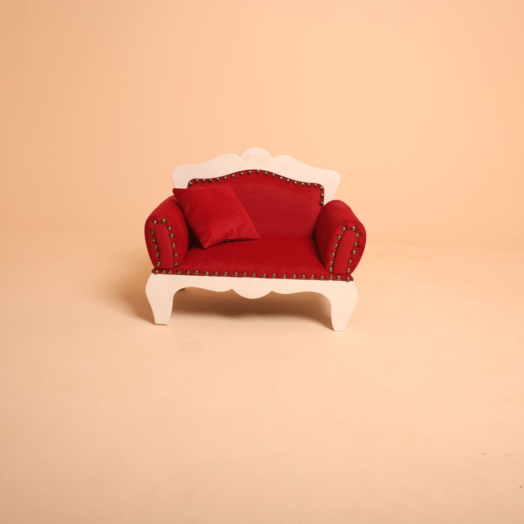Bold red baby posing sofa for professional photography.