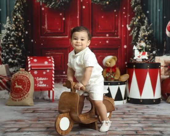 Sitter baby posing on a scooter prop for professional baby photography sessions.