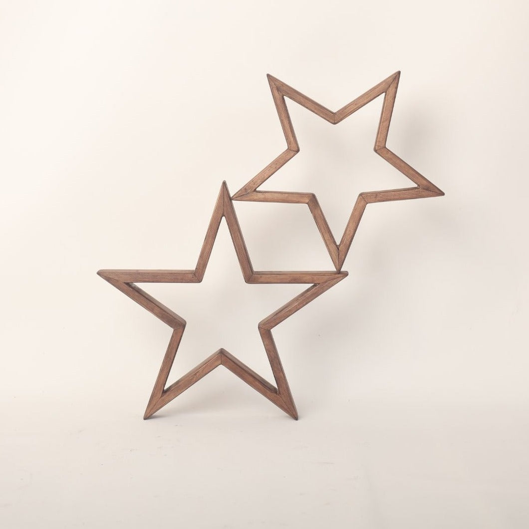 An arrangement of wooden stars, painted in soft pastel colors, hangs delicately above a baby's crib. Each star is intricately crafted, with visible wood grain adding texture to the surface. The stars are suspended by thin, transparent strings, creating a whimsical and enchanting display. Soft light casts gentle shadows on the wall behind, creating a serene and cozy atmosphere. This charming baby prop adds a touch of rustic elegance to any nursery, inviting dreams and imagination to flourish.