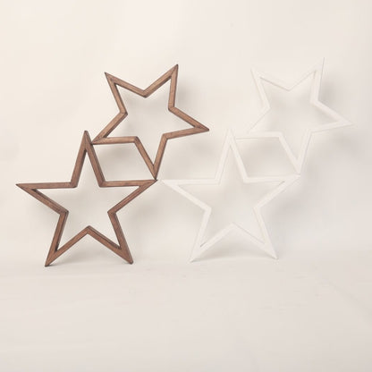 An arrangement of wooden stars, painted in soft pastel colors, hangs delicately above a baby's crib. Each star is intricately crafted, with visible wood grain adding texture to the surface. The stars are suspended by thin, transparent strings, creating a whimsical and enchanting display. Soft light casts gentle shadows on the wall behind, creating a serene and cozy atmosphere. This charming baby prop adds a touch of rustic elegance to any nursery, inviting dreams and imagination to flourish.