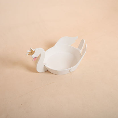 Newborn baby sleeping inside a white swan prop for an elegant and fairy-tale themed baby photoshoot.